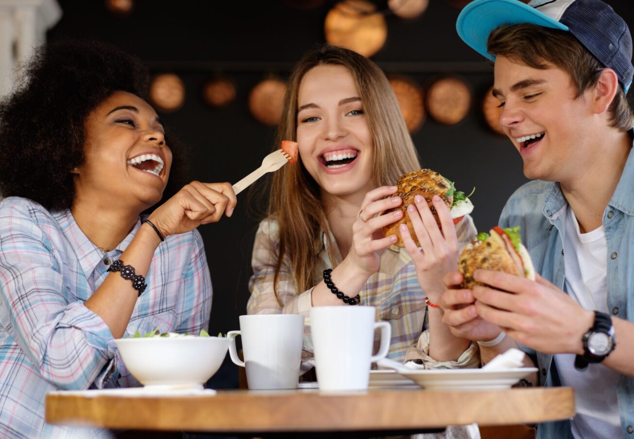 Cheerful,Multiracial,Friends,Eating,In,A,Cafe