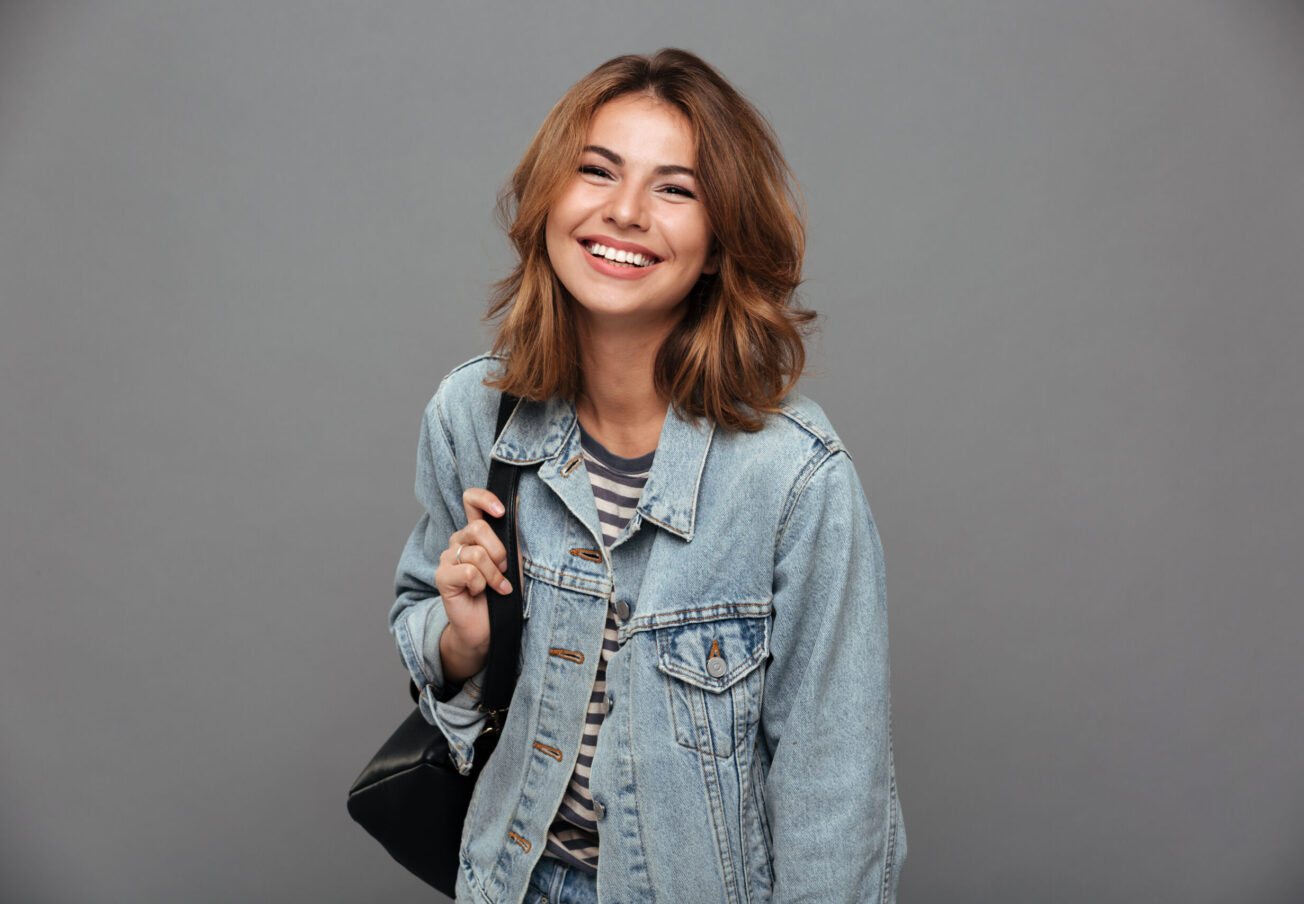 Portrait,Of,A,Cheery,Pretty,Girl,In,Denim,Jacket,Holding