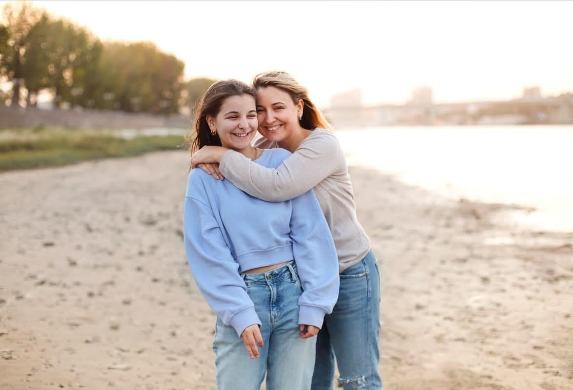 teen daughter and mother on beach