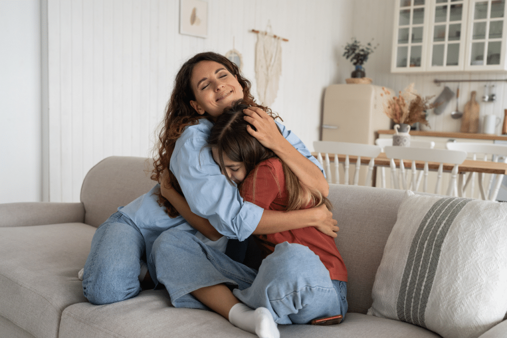 mother embracing her daughter after getting treatment for teenager playing on the computer showing signs of hyperfixation in teens