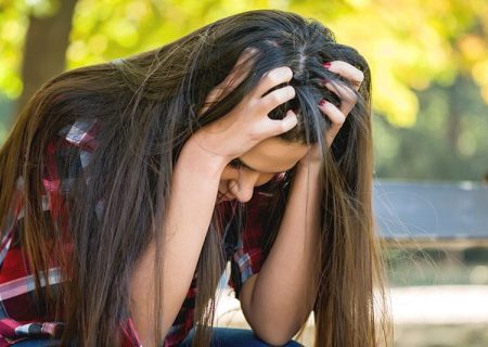 Close up portrait of a sad woman sitting on bench